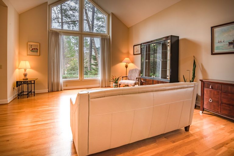 Inviting living room featuring large windows, modern decor, and wooden flooring