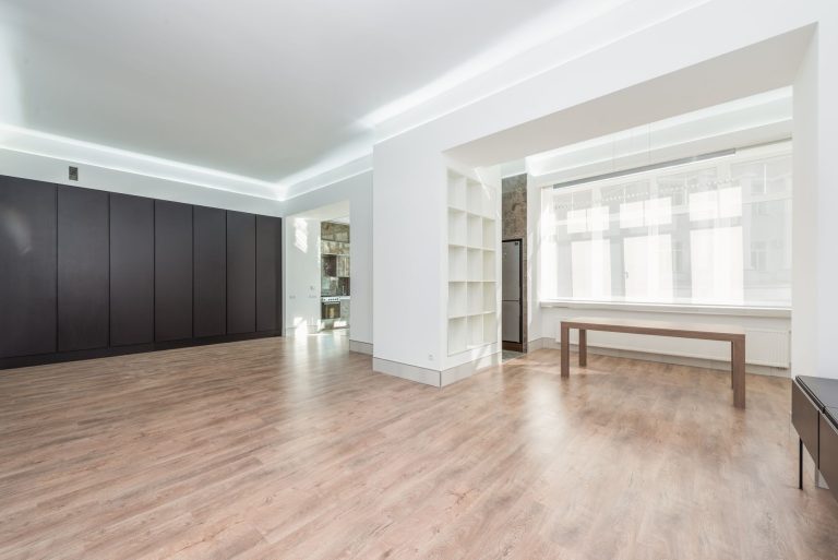 Refinished hardwood flooring in a sunlit empty Colorado room