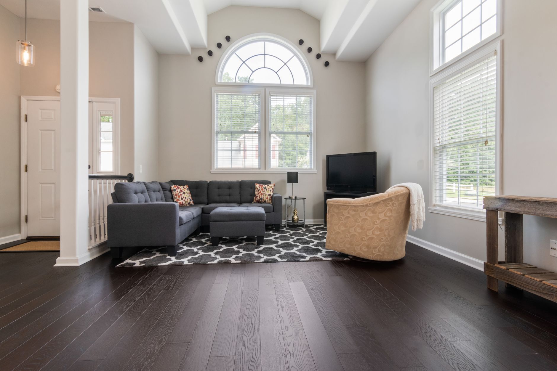 Bright living room with modern furniture, high ceilings, and big windows